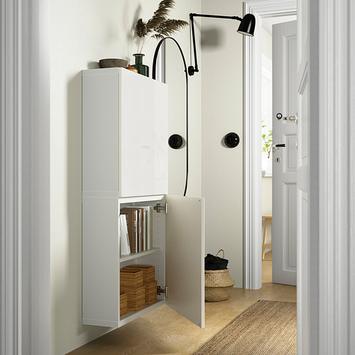 Open white cabinet reveals storage baskets and books, mounted on wall with adjustable hinges for space savings.