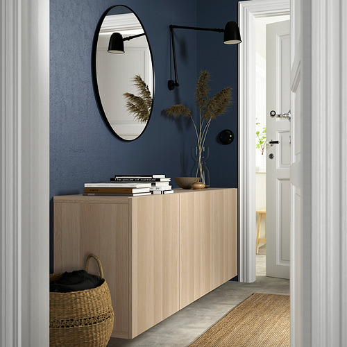 Pasillo con mueble de roble LAPPVIKEN, espejo, apliques, plantas, libros, cesta debajo. Pared azul, diseño elegante.