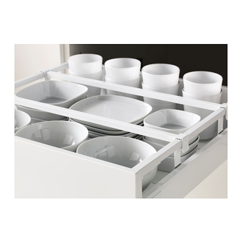Cajón de cocina abierto con tazas y tazones blancos perfectamente organizados, parte del sistema METOD de ikea.