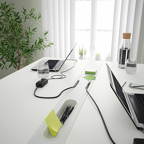Moderna mesa de conferencias con ordenadores portátiles, accesorios y gestión de cables.