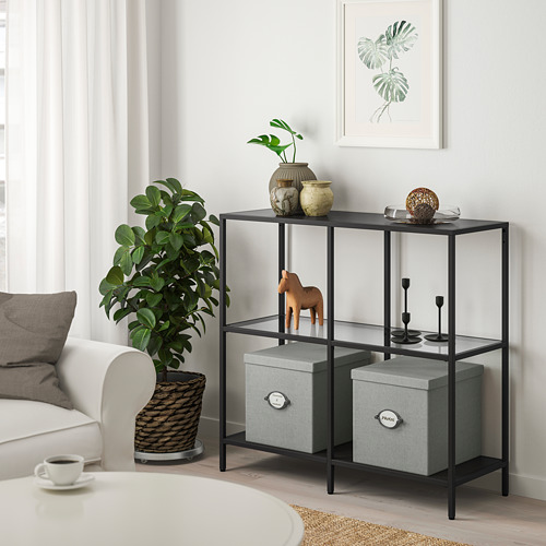 La estantería VITTSJÖ contiene decoración, jarrones, figuritas de caballos, cajas de almacenamiento.