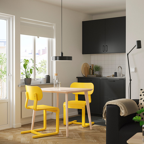 Cocina moderna con juego de comedor LISABO amarillo bajo una gran ventana y gabinetes negros.