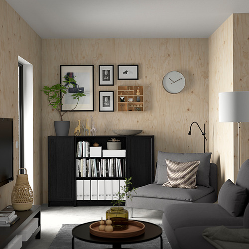 Minimalist living room with BILLY bookcase, grey sofa, wooden walls, and decorations.