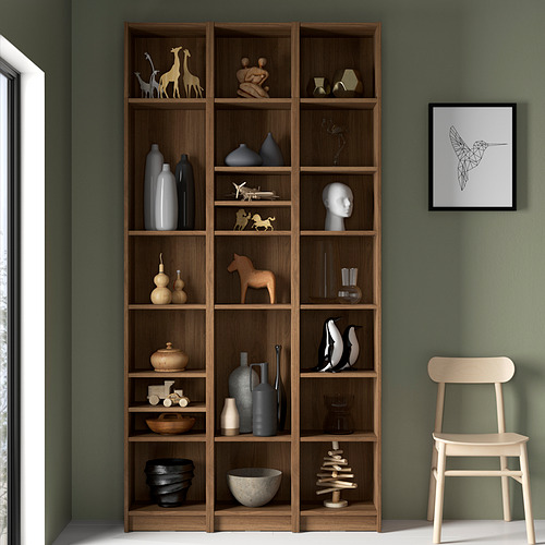 Librería BILLY con decoración contra pared verde, silla, estampado de colibríes.