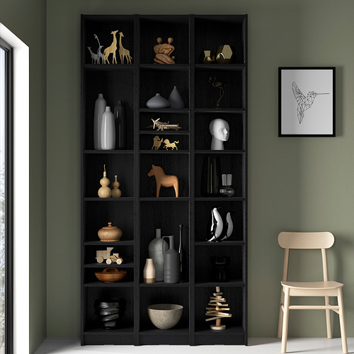 Gran librería BILLY en madera oscura con decoración variada. Alto, lleno de adornos, jarrones y figuritas. Obras de arte y silla de madera cerca.