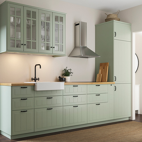 Modern green kitchen with light wood countertop, featuring STENSUND cabinets in green, smooth surfaces, and a stainless steel hood.