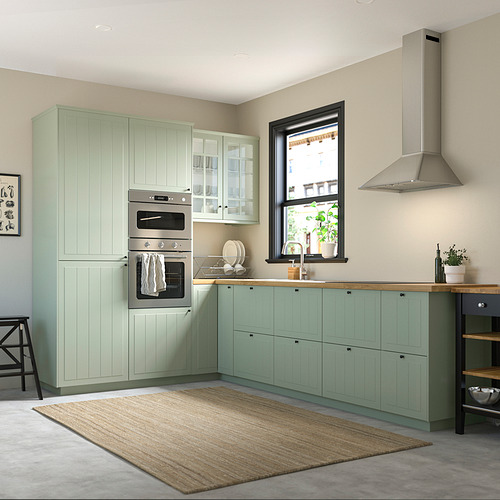 Modern kitchen with STENSUND light green cabinets, stainless steel oven, and large window. Rug under.