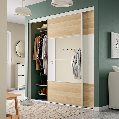 Moderno salón verde con armario abierto, ropa, estantes, ganchos y luces colgantes.
