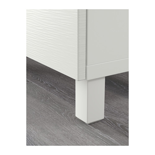 Primer plano de la pata del armario blanco, parte de una unidad de almacenamiento moderna. Exhibe un diseño limpio y elegante y una construcción robusta.