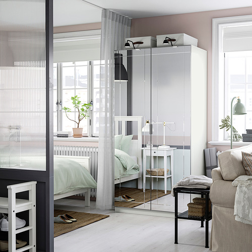 Dormitorio moderno con armario KAMMARTORP, cama, mesita de noche y sofá.