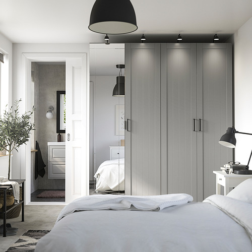Modern bedroom with gray PAX wardrobe, mirrored door, white bed, and black accents.