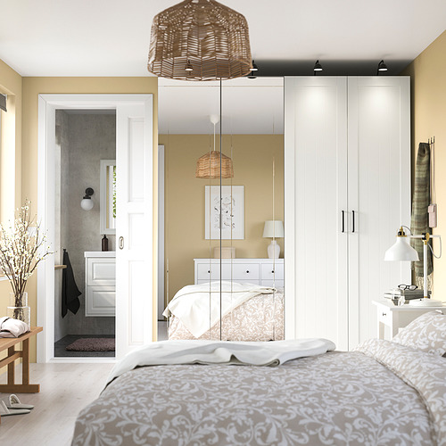 Acogedor dormitorio con gran armario con espejo, lámpara colgante y mesita de noche.