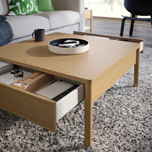 Mesa de centro de madera con dos cajones abiertos, con capacidad para libros y una bandeja con bolígrafos.