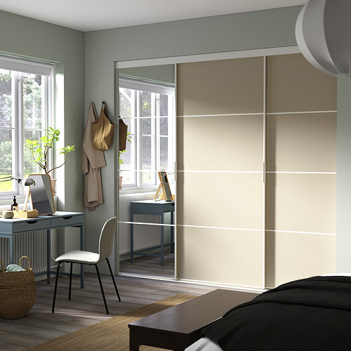 Dormitorio moderno con un gran armario SKYTTA con espejos, escritorio debajo de la ventana, silla acogedora y decoración.
