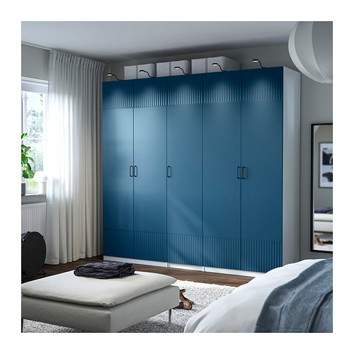 Blue PAX wardrobe in bedroom, larger than bed, with multiple drawers and shelves.