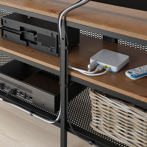Mueble de TV de madera con puertas de malla, que alberga dispositivos electrónicos como un dispositivo de transmisión, una barra de sonido, una consola de juegos y controles remotos.