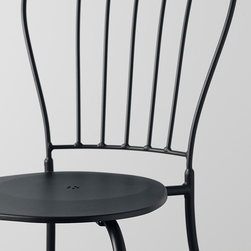 Silla moderna de metal negro con asiento circular, con un intrincado diseño de respaldo y una construcción robusta. Ideal para uso en exteriores.