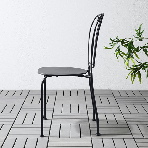 Silla de exterior LÄCKÖ negra con asiento redondo y orificio.