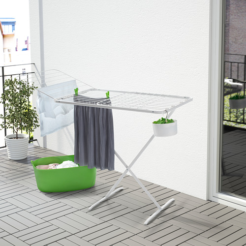 Tendedero multi blanco con alas en el balcón, rodeado de plantas y una cesta verde, resistente con 4 ganchos.
