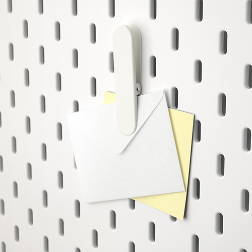 Tablero perforado blanco con gancho SKÅDIS que sostiene letras.