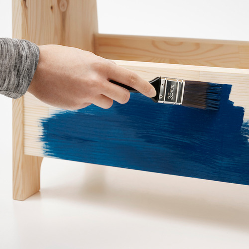 Taburete de madera pintado con asas recortadas, versátil como asiento, mesa o almacenamiento.