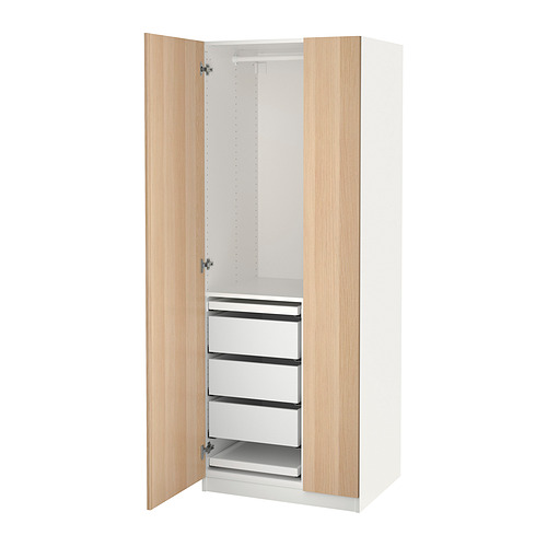 An open white PAX wardrobe with light wooden doors, featuring drawers and trays inside.