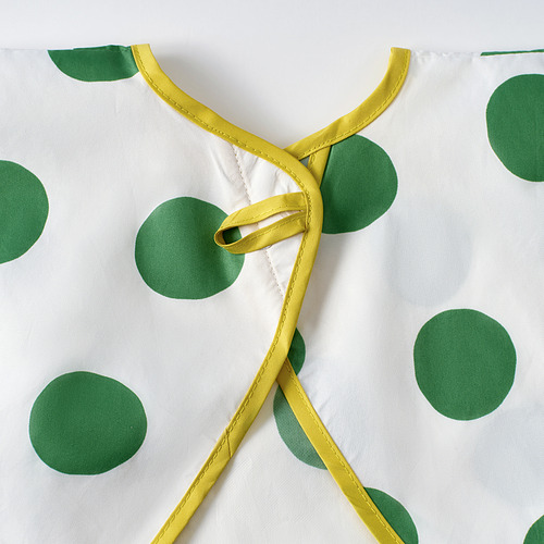 Primer plano del babero KLADDIG: lazos amarillos, lunares verdes, tejido suave. Babero infantil elegante, ajustable y de calidad.
