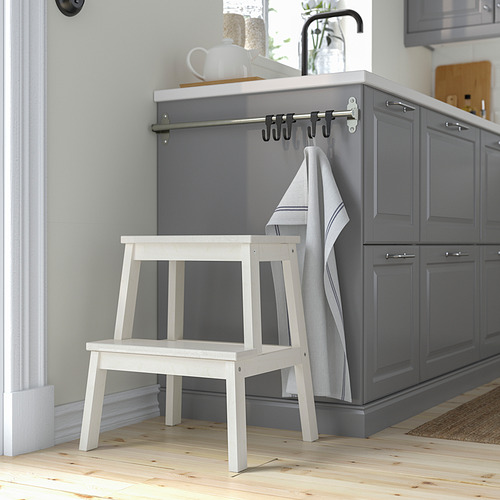 Taburete BEKVÄM blanco junto a armarios grises. Madera de álamo temblón compacta y estable, se mueve con facilidad.