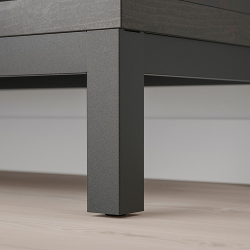 Moderna pata de mesa de metal con acabado texturizado, que soporta una superficie elegante sobre el suelo de madera.