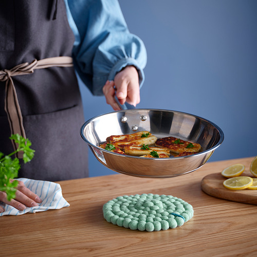 La persona cocina en una sartén con limón y un paño.
