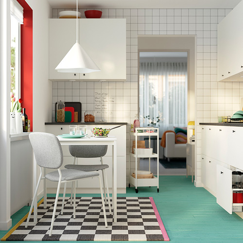 Pequeña cocina moderna con gabinete blanco, silla gris VIHALS, alfombra a cuadros negros y pisos verdes.