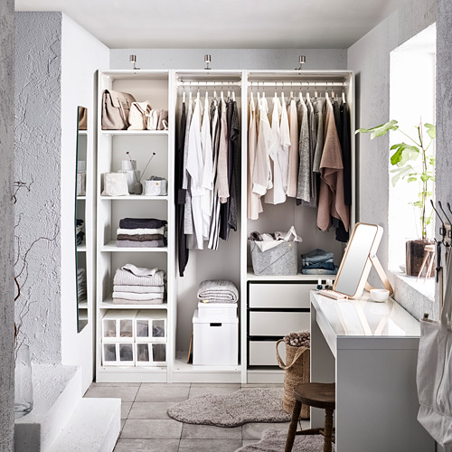Armario blanco moderno con ropa, estanterías y cajones. Un espejo y una planta a su lado.