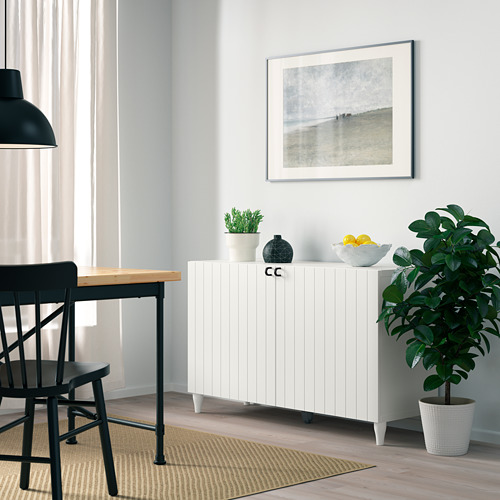 Minimalist dining area with BESTÅ unit, chair, lamp, and decor.