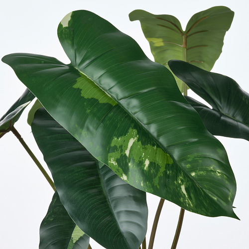 Hojas de plantas artificiales vibrantes y realistas con textura realista y tonos verdes, diseñadas con materiales reciclados para una decoración ecológica.