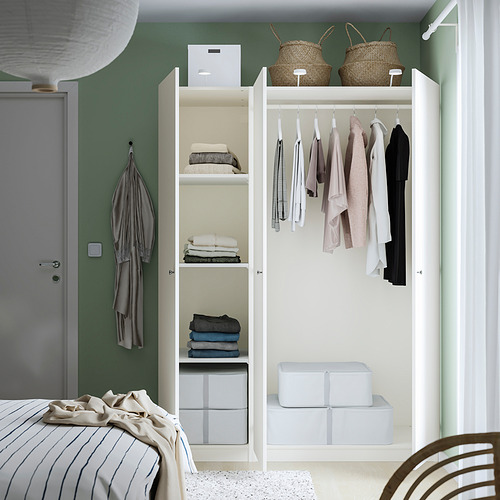 A well-organized closet with clothes hangers and shelves storing folded clothes and boxes.