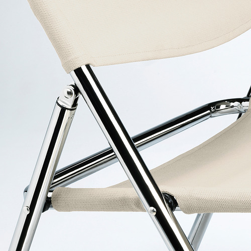 Silla moderna con patas cromadas relucientes y tela beige, que muestra un diseño elegante y artesanía de calidad.