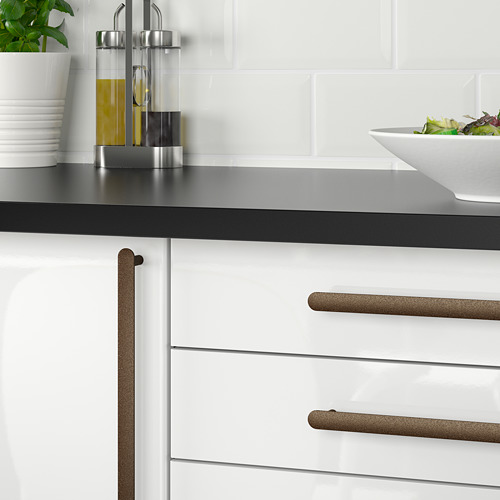 Manijas de cocina NYDALA doradas, elegantes y horizontales, gabinetes blancos contrastantes y encimera negra.