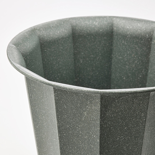 Primer plano de una maceta BUSKVERK verde que muestra su textura acanalada y su material reciclado duradero.