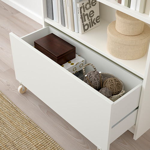 Abra el cajón BILLY que revela el almacenamiento oculto con una cesta simple y ecológica y una caja de madera en el interior.