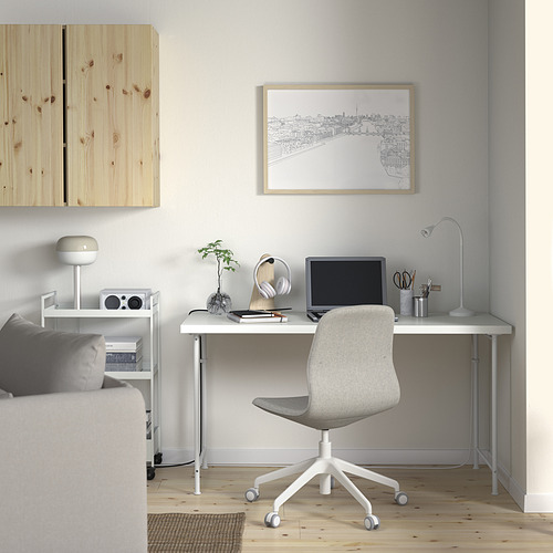 Oficina en casa minimalista con escritorio, monitor, planta, estampado de paisaje urbano, estantería, lámpara, altavoz y sofá LAGKAPTEN.