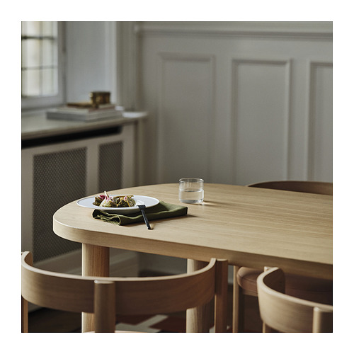 Una mesa de comedor de madera con sillas. La mesa tiene un plato y un vaso. La mesa está rodeada de sillas de madera.
