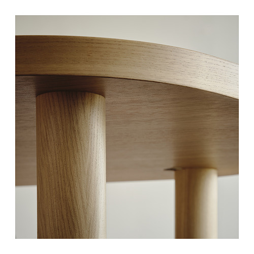 Primer plano de una mesa de madera elegante y moderna con un acabado de madera suave y clara y patas cilíndricas, que muestra una artesanía de alta calidad.