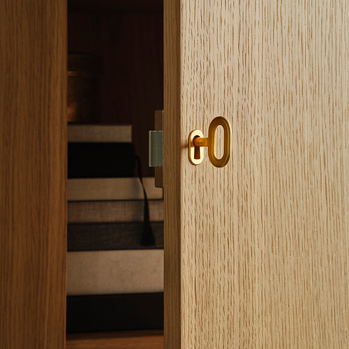 Primer plano de un armario de madera clara con cerradura y llave de color dorado, con un acabado de alta calidad y un diseño elegante.