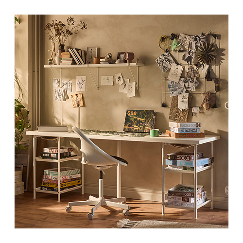 Configuración de la oficina en casa: escritorio SPÄND blanco con ruedas, estantes para rompecabezas y libros, tablón de anuncios, silla, plantas.