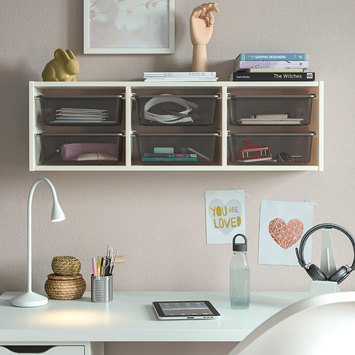 Mueble alto compacto TROFAST blanco, con cajas de almacenamiento de malla, con varios artículos, situado sobre un escritorio blanco con accesorios.