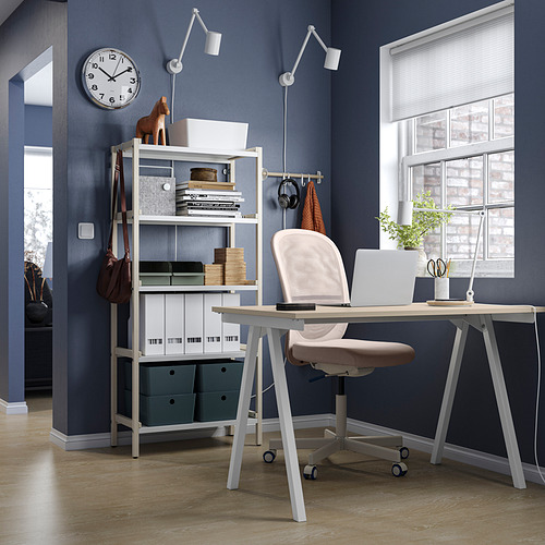 Moderna oficina en casa con estantería blanca EKENABBEN, silla de escritorio beige, computadora portátil, planta en maceta, ventana, reloj de pared y cajas de almacenamiento.