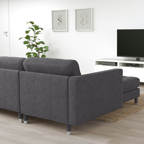 Moderno sofá modular gris LANDSKRONA en salón minimalista cerca de la televisión y la puerta.