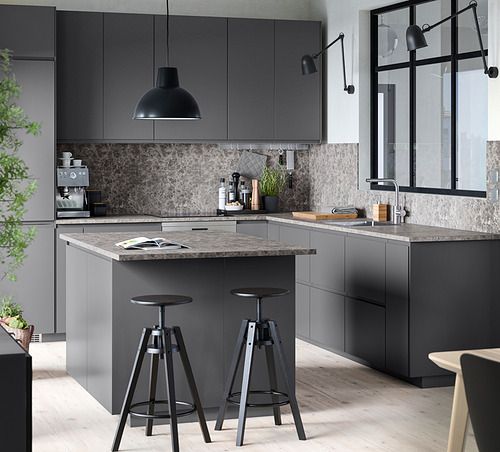 Cocina moderna gris con elegantes gabinetes, encimera de mármol, colgantes negros y taburetes de bar.