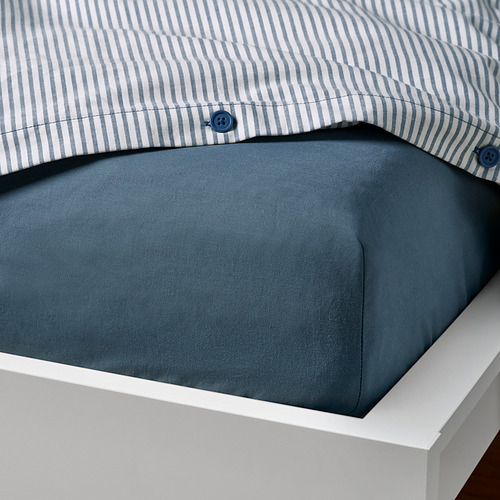 Un juego de sábanas azules con una funda de almohada a rayas.