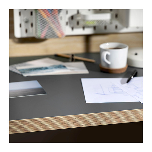 Escritorio con tablero negro, taza blanca, papeles y bolígrafo.